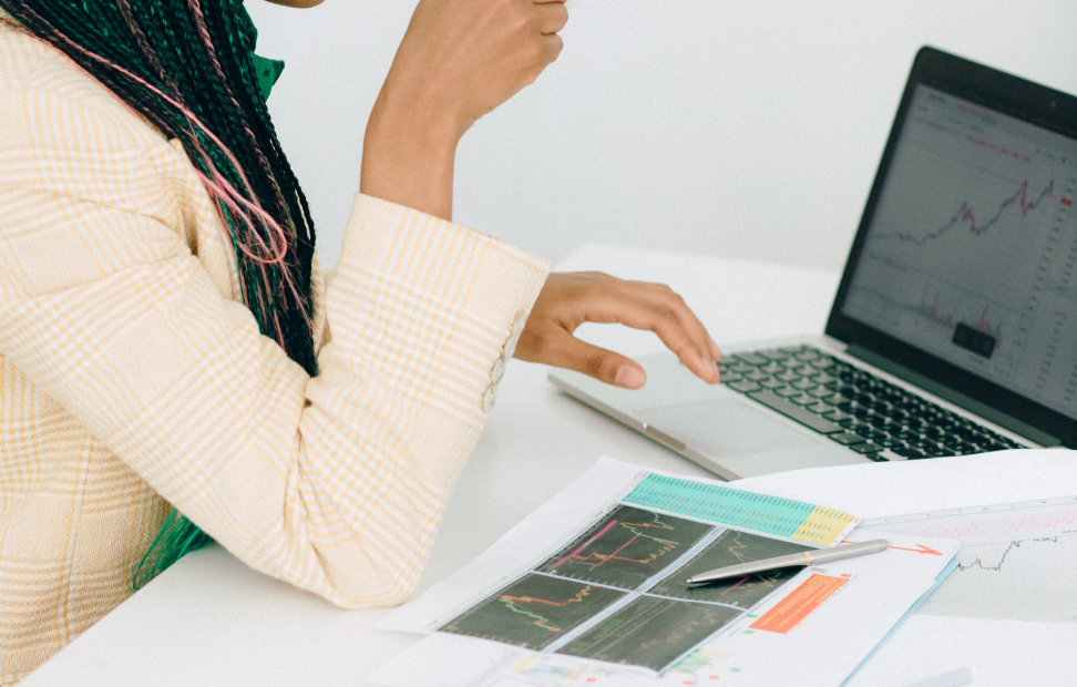 A person using a laptop to view charts